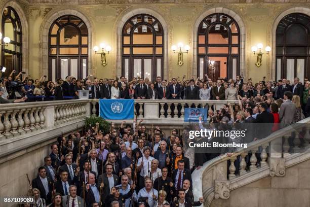 Carles Puigdemont, Catalonia's president, center, and Oriol Junqueras, Catalonia's vice president, center left, sing the Catalan anthem with...