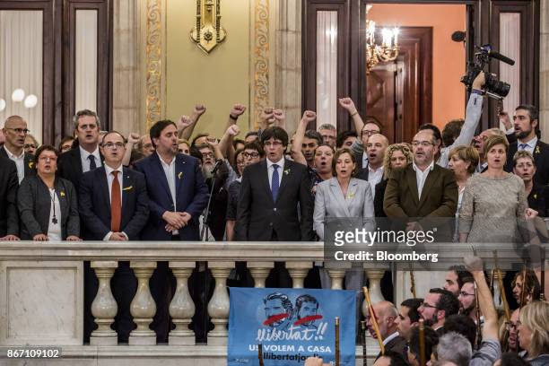 Carles Puigdemont, Catalonia's president, center, and Oriol Junqueras, Catalonia's vice president, center left, sing the Catalan anthem with pro...