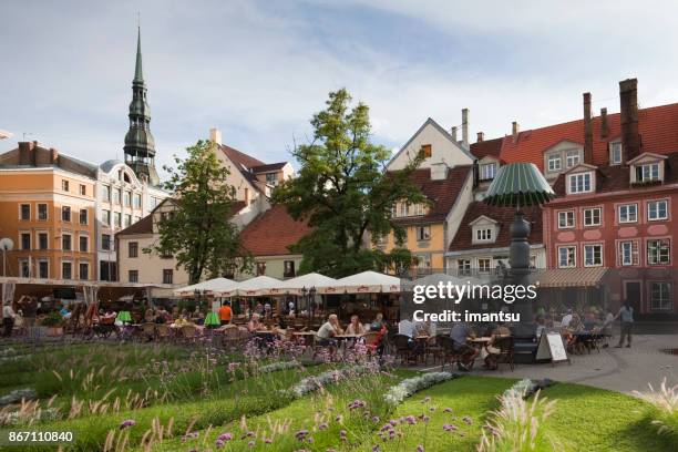 calle café con turistas en la plaza livu en el casco antiguo de riga - livu square fotografías e imágenes de stock