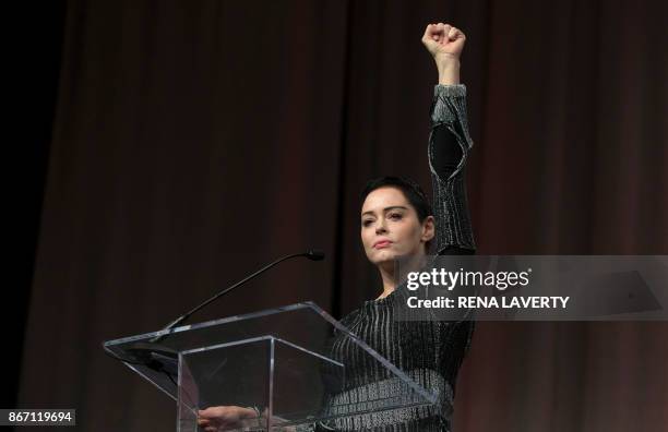Actress Rose McGowan raises her fist during her opening remarks to the audience at the Women's March / Women's Convention in Detroit, Michigan, on...