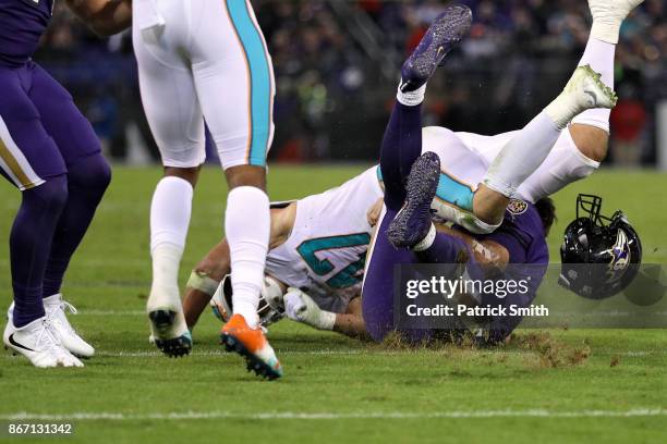 Quarterback Joe Flacco of the Baltimore Ravens is tackled by middle linebacker Kiko Alonso of the Miami Dolphins during the second quarter at M&T...