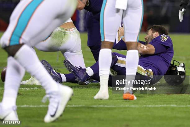 Quarterback Joe Flacco of the Baltimore Ravens is tackled by middle linebacker Kiko Alonso of the Miami Dolphins during the second quarter at M&T...