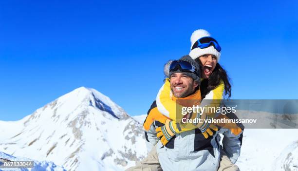 jong (echt) paar skiërs plezier op top sneeuw berg - bansko stockfoto's en -beelden