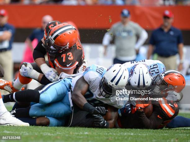 Running back Duke Johnson Jr. #29 of the Cleveland Browns is tackled by cornerback Logan Ryan and linebacker Brian Orakpo of the Tennessee Titans, as...