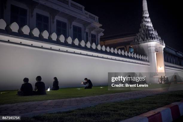 Mourners take photographs outside Wat Phra Kaew, or the Temple of the Emerald Buddha on October 27, 2017 in Bangkok, Thailand. Tens of thousands of...