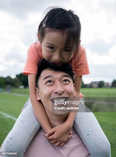 Asian father and daughter having fun at the park