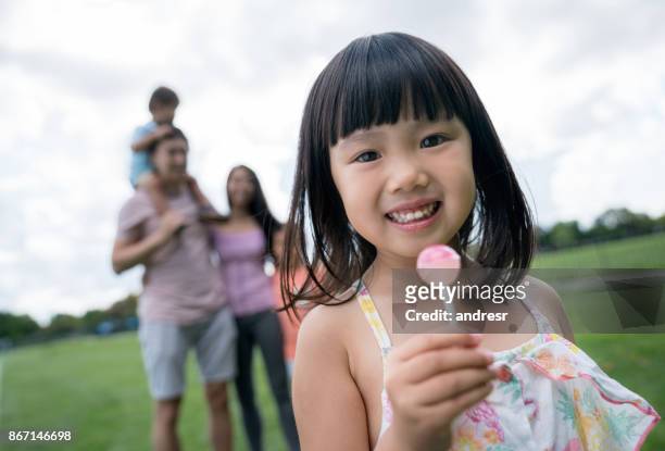 aziatisch meisje een lolly met haar familie eten op het park - lollipop man stockfoto's en -beelden