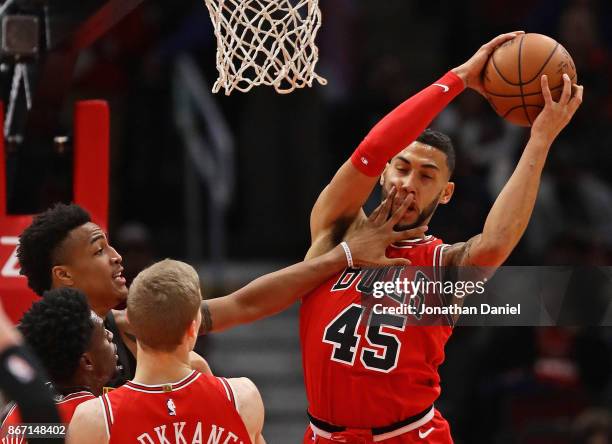 Denzel Valentine of the Chicago Bulls as John Collins of the Atlanta Hawks gets a hand in his face at the United Center on October 26, 2017 in...
