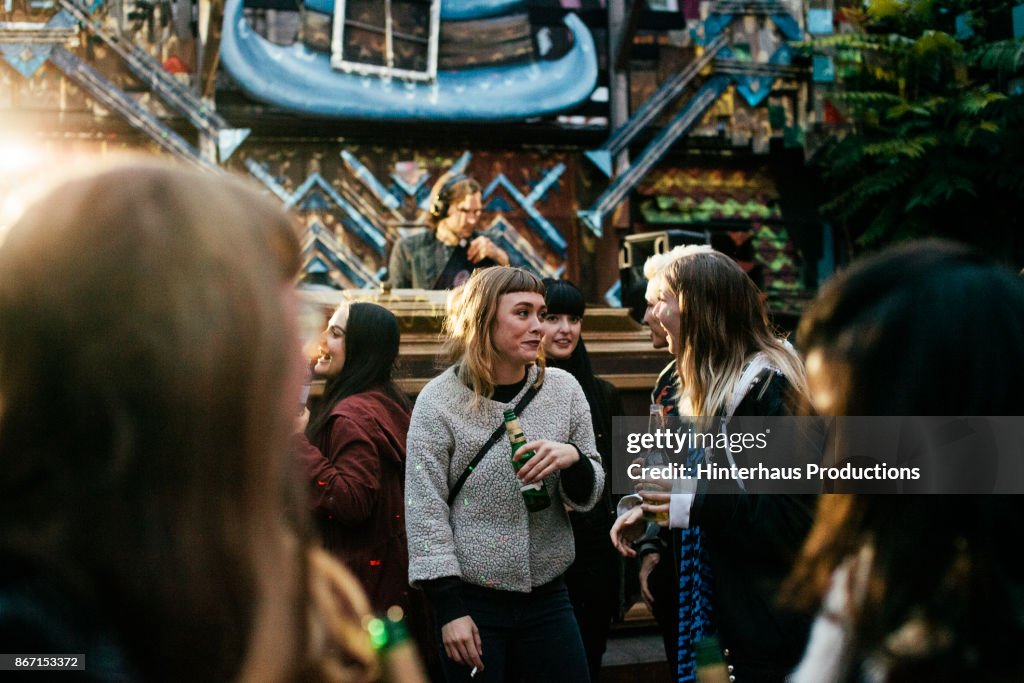 Friends Chatting And Drinking At Club Together