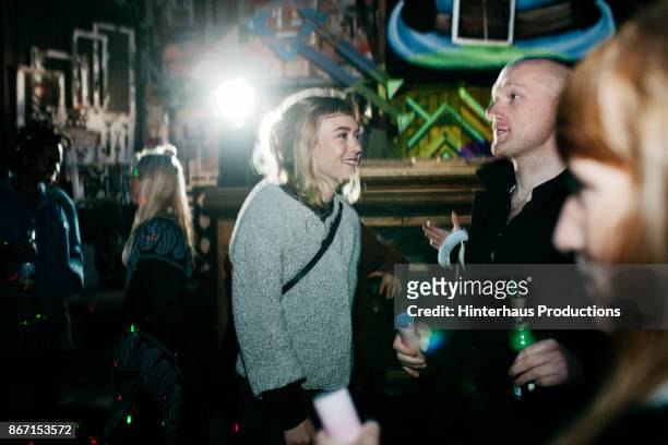partygoers dancing at colourful open air club event - berlin nightlife stock pictures, royalty-free photos & images