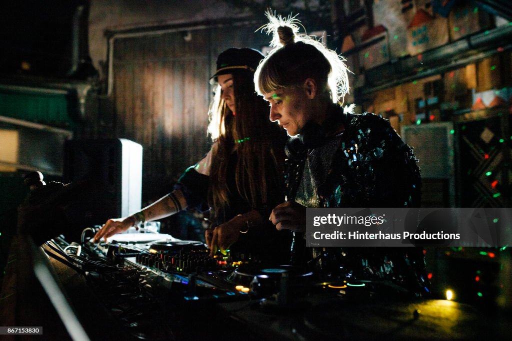 Two Stylish DJs Performing Together At Open Air Nightclub