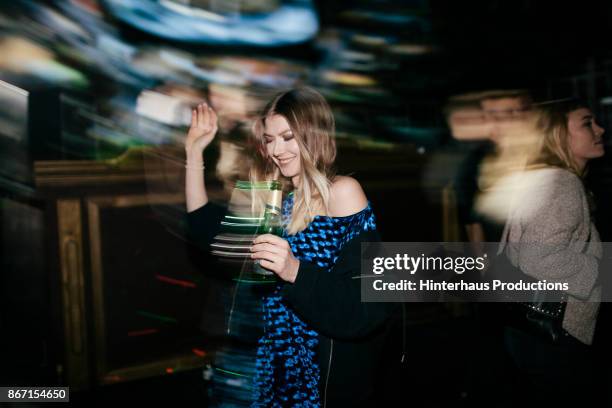 young woman dancing while drinking at nightclub - night club stock-fotos und bilder