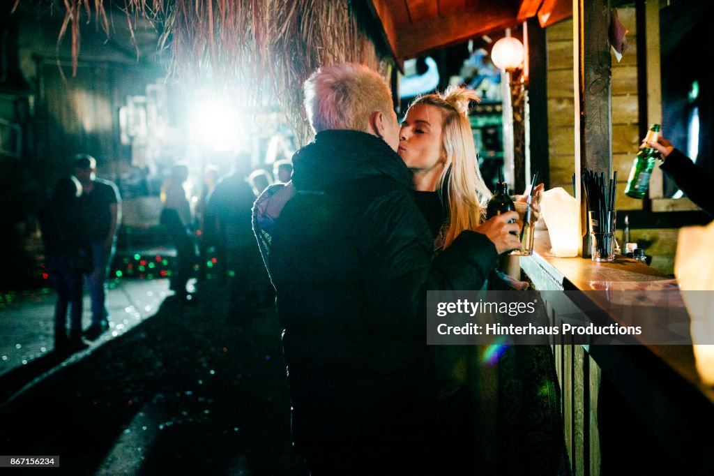 Couple Standing At The Bar, Embracing And Kissing At Nightclub