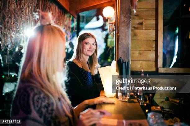 girls waiting at bar to be served while out clubbing together - bar outside stock-fotos und bilder