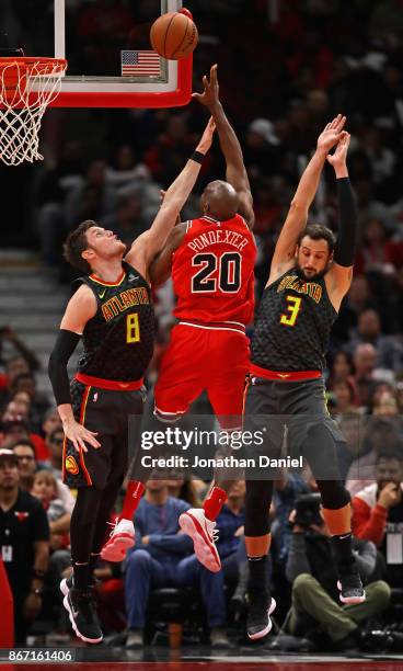Quincy Pondexter of the Chicago Bulls shoots between Luke Babbitt and Marco Belinelli of the Atlanta Hawks at the United Center on October 26, 2017...