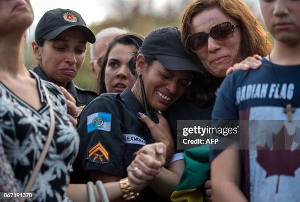 Military policewomen cry at the funeral of police colonel Luis Gustavo Teixeira in Sulacap, in western Rio de Janeiro, Brazil, on October 27 a day...