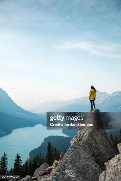 hiking above a lake - yellow jacket stockfoto's en -beelden