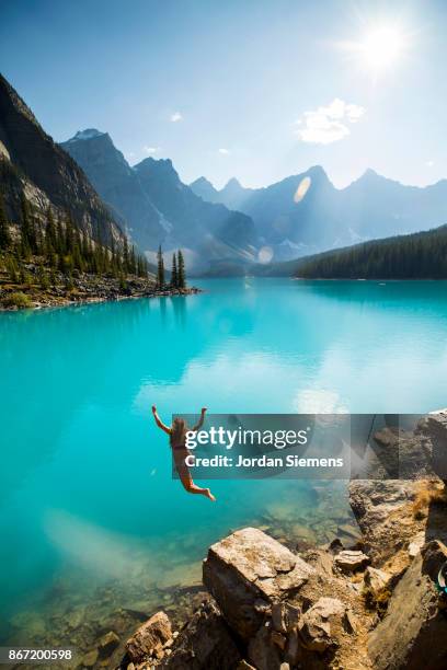 jumping into a cold mountain lake - banff stockfoto's en -beelden