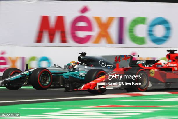 Lewis Hamilton of Great Britain driving the Mercedes AMG Petronas F1 Team Mercedes F1 WO8 passes Sebastian Vettel of Germany driving the Scuderia...