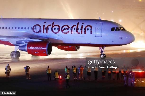 Fire trucks shoot ceremonial bursts of water as ground crews wave to celebrate the arrival of Air Berlin flight AB 6210 from Munich at Tegel Airport...