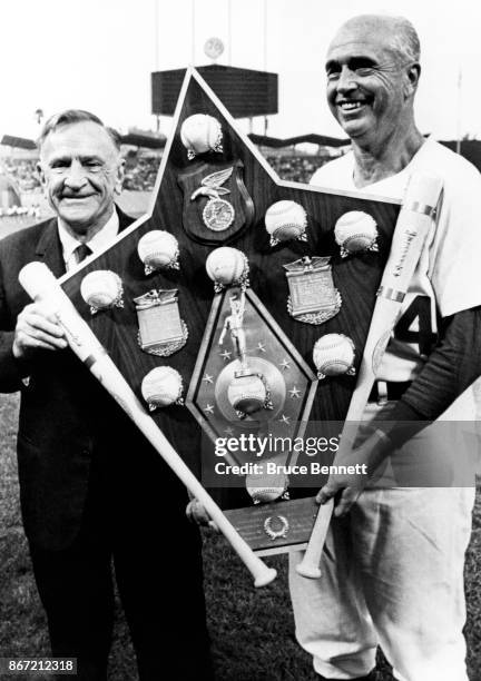 Casey Stengel presents manager Walter Alston of the Los Angeles Dodgers with a trophy after he managed the 1966 National League All-Stars on July 20,...