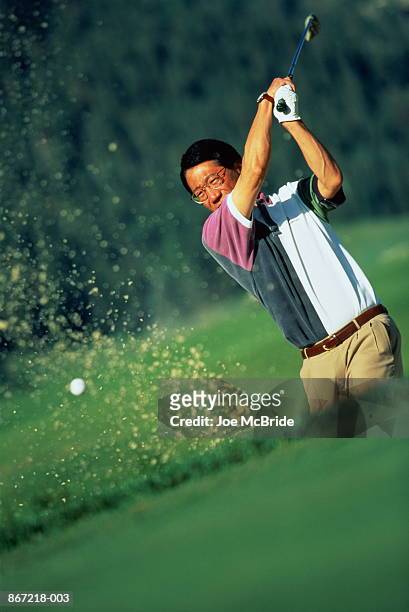 golfer hitting ball out of bunker - spectacles bunkers stock pictures, royalty-free photos & images