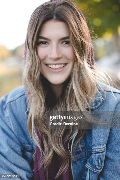 close-up of attractive young woman smiling with hood up - maroon hair stock pictures, royalty-free photos & images