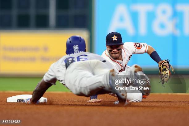 Yasiel Puig of the Los Angeles Dodgers slides in to second and is tagged out by Jose Altuve of the Houston Astros during the fourth inning in game...