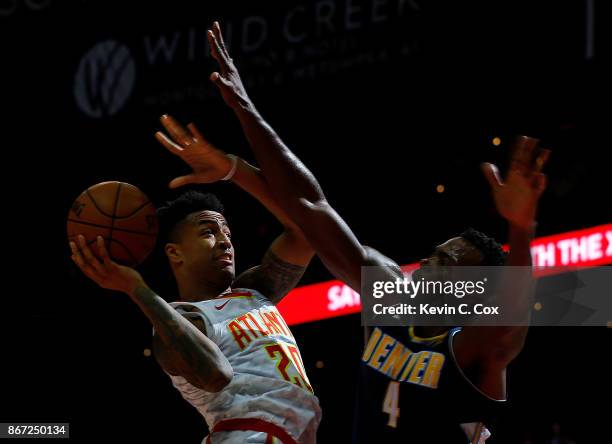 John Collins of the Atlanta Hawks drives against Paul Millsap of the Denver Nuggets at Philips Arena on October 27, 2017 in Atlanta, Georgia. NOTE TO...