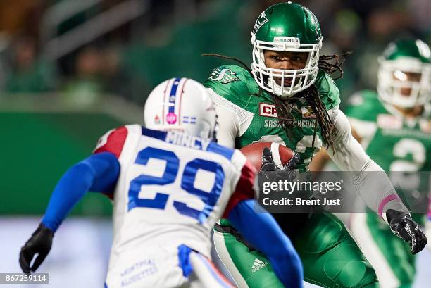 Trent Richardson of the Saskatchewan Roughriders looks to avoid Jonathon Mincy of the Montreal Alouettes during a run in the first half of the game...