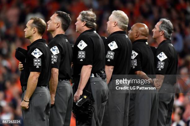 The umpiring crew stand behind second base during the singing of the God Bless America during Game 3 of the 2017 World Series between the Los Angeles...