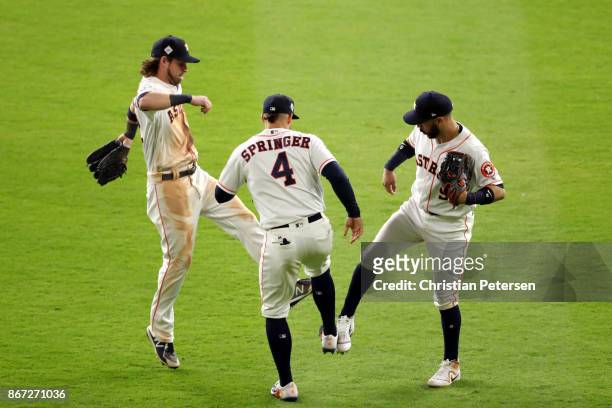 Marwin Gonzalez, Josh Reddick and George Springer of the Houston Astros celebrate after defeating the Los Angeles Dodgers in game three of the 2017...