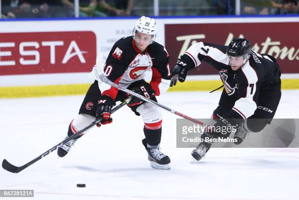 Josh Curtis of the Prince George Cougars skates with the puck against Ty Ronning of the Vancouver Giants during the third period of their WHL game at...