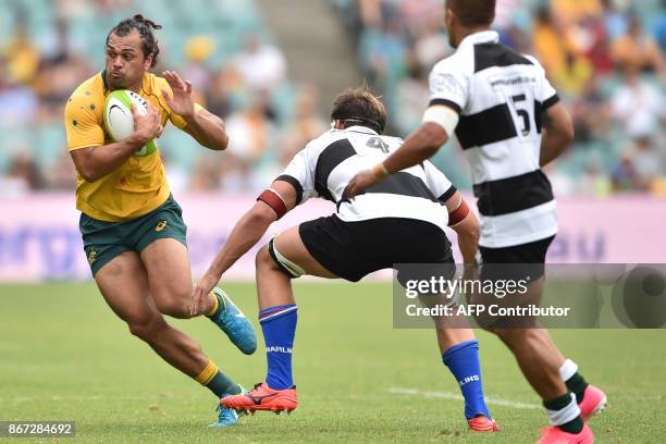 Australia's Karmichael Hunt avoids Barbarians' Luke Jones and Sam Carter during their rugby union match in Sydney on October 28, 2017. / AFP PHOTO /...