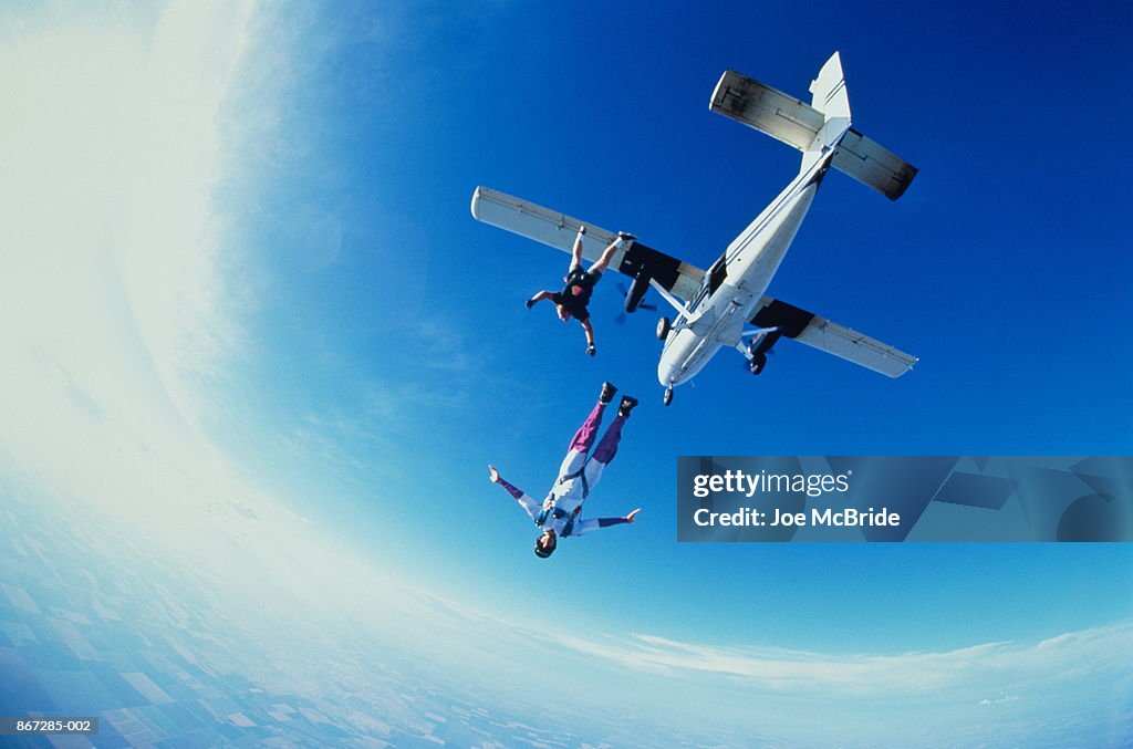 Two skydivers jumping off an airplane