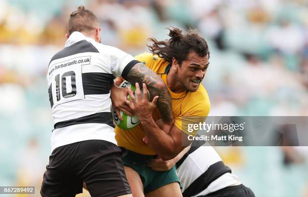 Karmichael Hunt of the Wallabies is tackled during the match between the Australian Wallabies and the Barbarians at Allianz Stadium on October 28,...