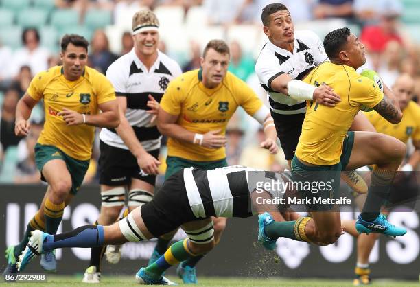 Israel Folau of the Wallabies is tackled by Tim Nanai-Williams of the Barbarians during the match between the Australian Wallabies and the Barbarians...