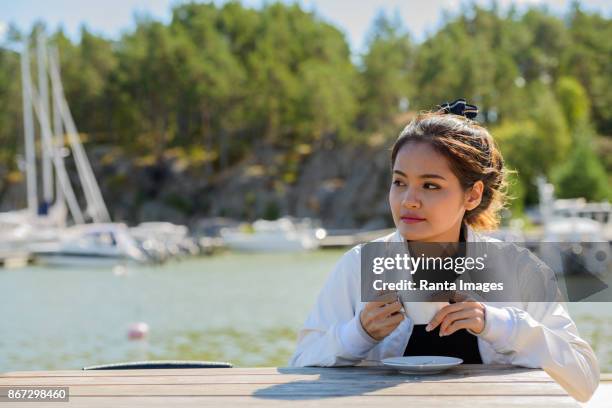 junge schöne asiatische frau entspannende gegen blick auf den pier - turku stock-fotos und bilder