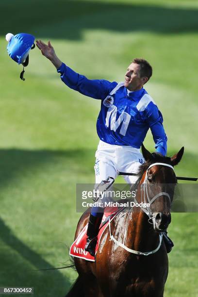 Hugh Bowman throws his helmet into the crowd on returning to scale after winning on Winx to win race 9 the Ladbrokes Cox Plate during Cox Plate Day...