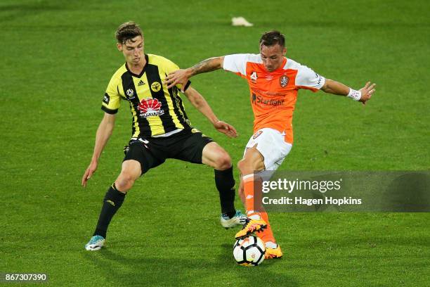 Eric Bautheac of Brisbane is challenged by Matthew Ridenton of the Phoenix during the round four A-League match between the Wellington Phoenix and...