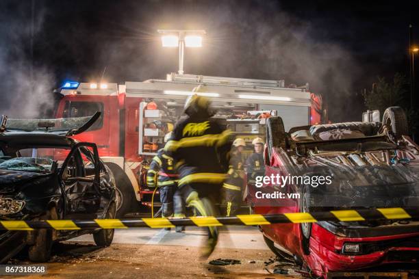 firefigters at a car accident scene - disaster rescue stock pictures, royalty-free photos & images