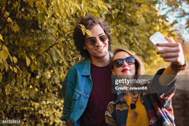 young couple making selfie in park - park man made space stock pictures, royalty-free photos & images