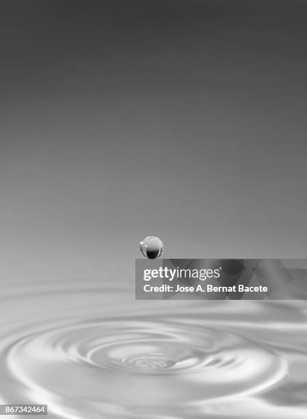 group of drops on line suspended in the air, falling down on a water surface that forms figures and abstract forms, on a gray background - onde sinusoïdale photos et images de collection