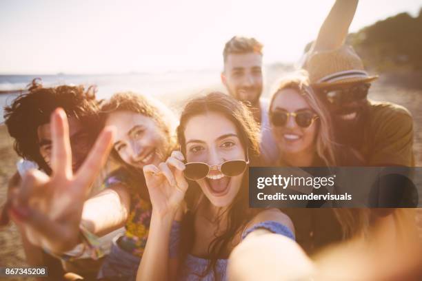 multi-ethnic friends taking selfies at the beach on summer holidays - beach party stock pictures, royalty-free photos & images