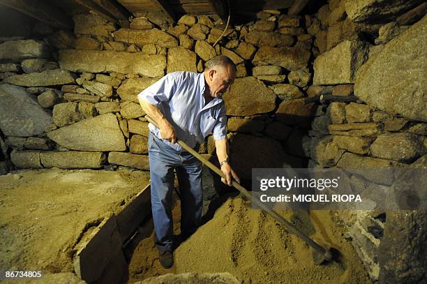 Portuguese winegrower Armindo Sousa Pereira digs up bottles of wine which he had buried in his cellar on May 5, 2009. Traditionally produced for...