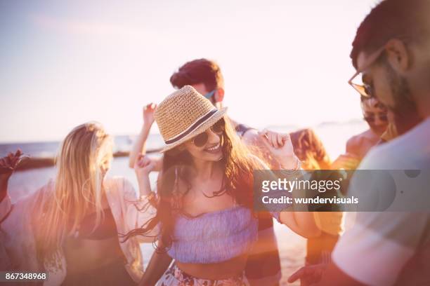 amigos de joven inconformista en vacaciones de verano bailando en la playa partido - party fotografías e imágenes de stock
