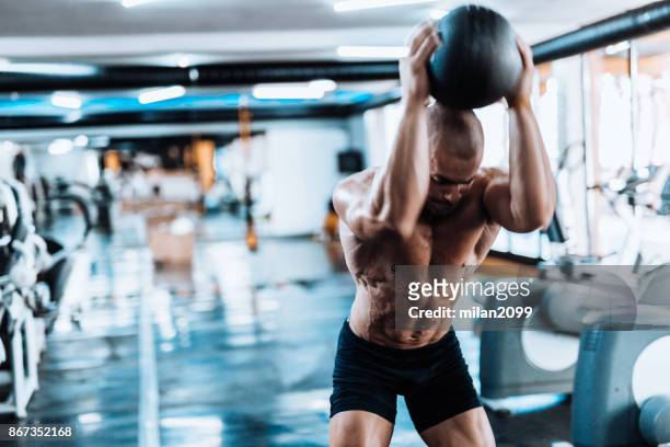 man exercising with medicine ball in the gym - medicine ball stock pictures, royalty-free photos & images