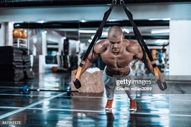 suspension straps exercise in the gym - suspension training stock pictures, royalty-free photos & images