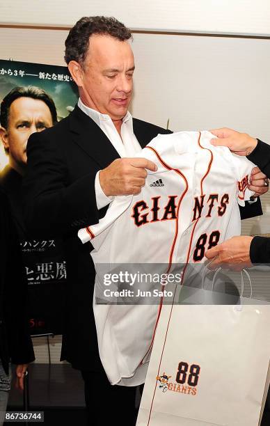 Actor Tom Hanks looks at a Giants shirt at the reception room during professional baseball match between Yomiuri Giants and Chunichi Dragons at Tokyo...
