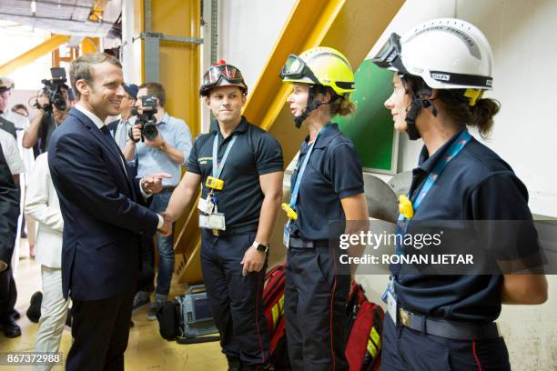 French President Emmanuel Macron shakes hands with technicians during a visit to the Guiana Space Centre in Kourou on October 27, 2017 as part of a...